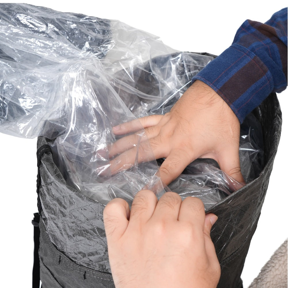Hands placing a clear polycro pack liner inside the main compartment of an ultralight backpack