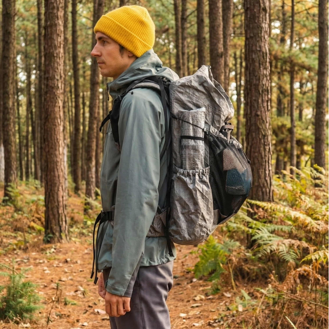 Hiker wearing HODRGEAR backpack with StashLite pole bag in forest trail