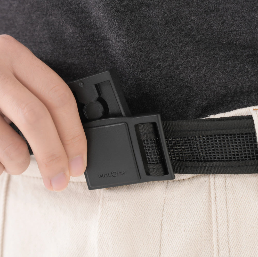 Hand adjusting FIDLOCK buckle on tactical belt worn over dark fabric