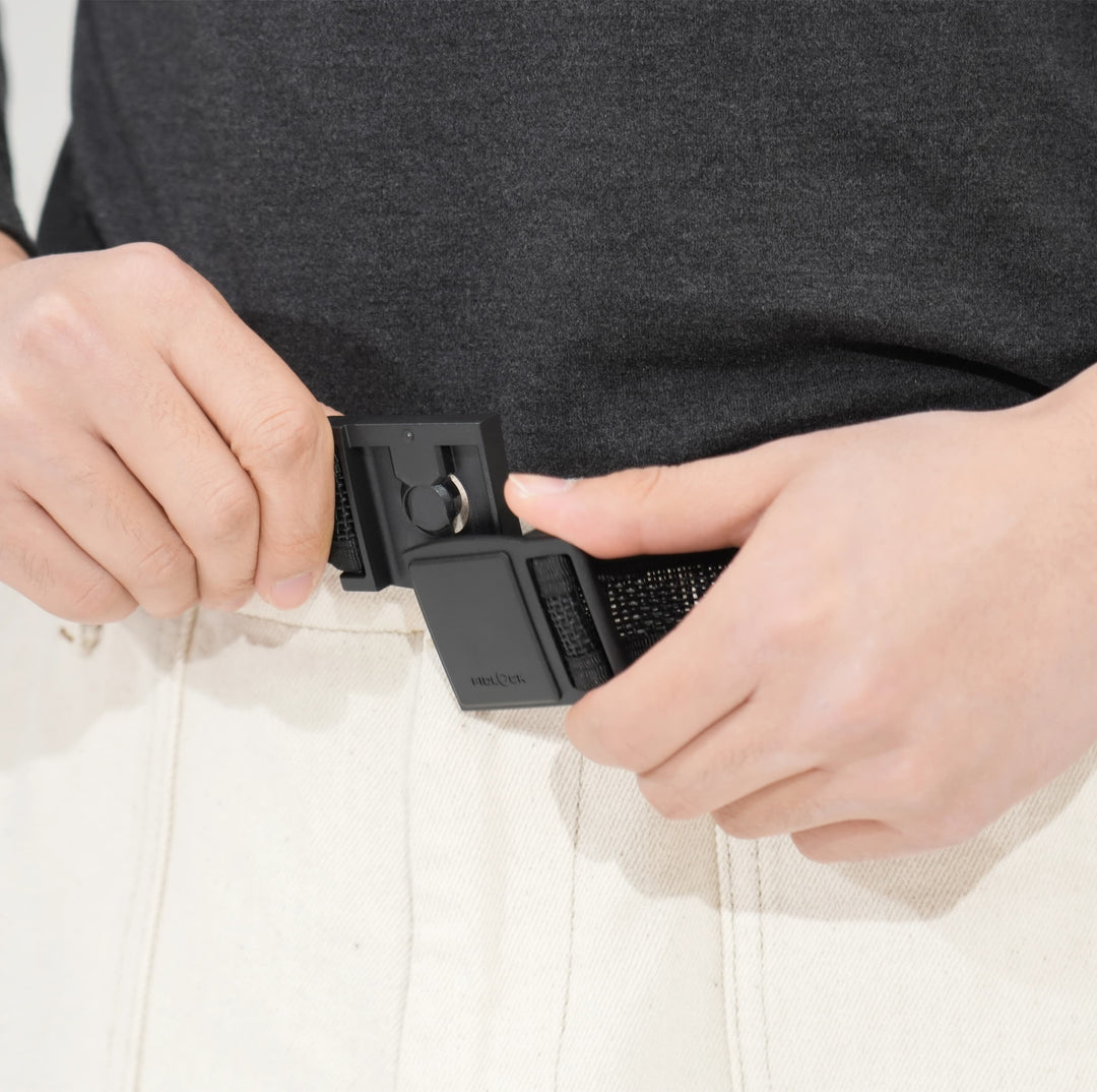 Hands adjusting FIDLOCK buckle on tactical belt with light pants