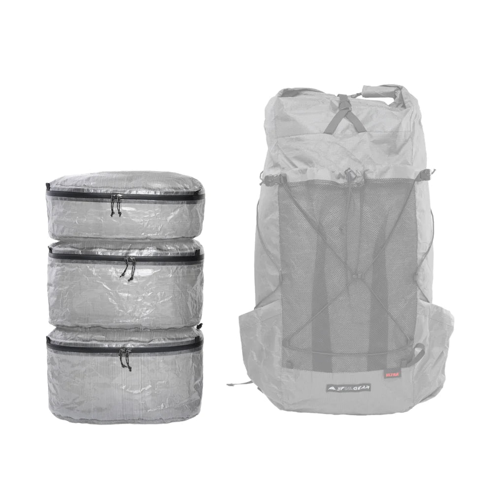 Set of gray Dyneema packing cubes and a backpack on a white background